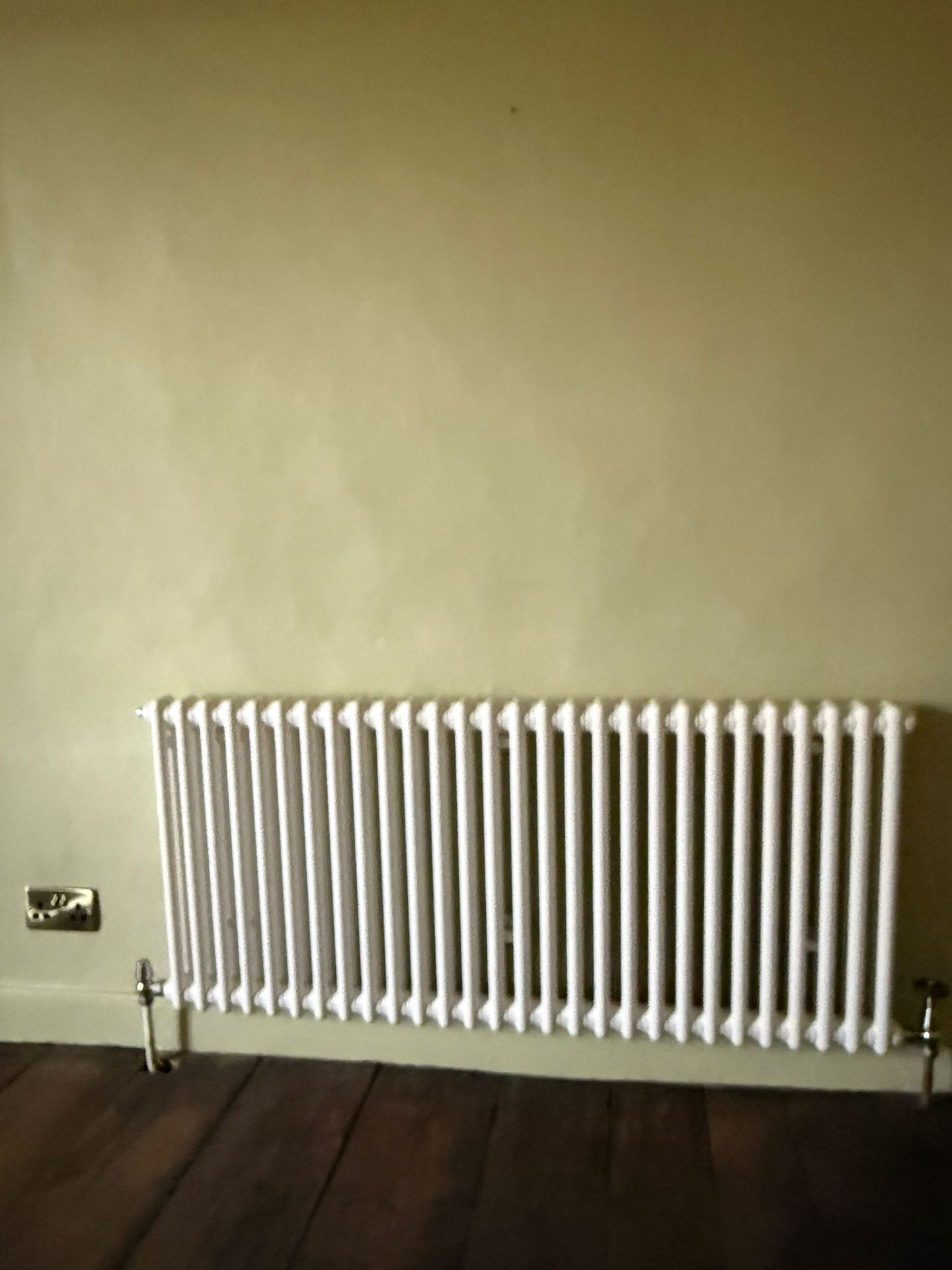 White column radiator installed with chrome valves in an Oxfordshire home