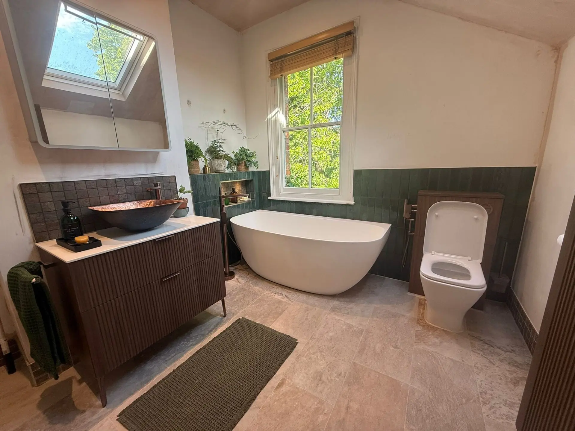 Completed bathroom installation with freestanding bath, green tiling and copper basin, Oxfordshire